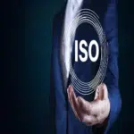A businessman holding a glowing ISO symbol